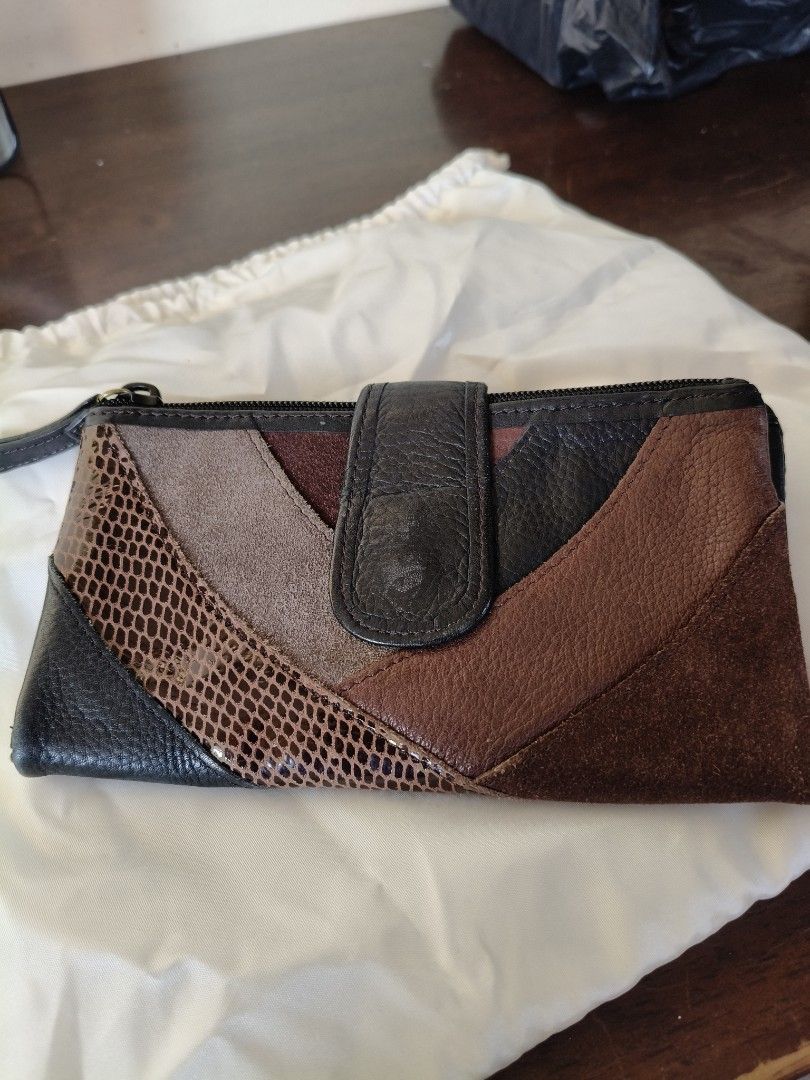 Fossil Multi-texture Patchwork Leather Wallet with Zipper Pocket (Category: Wallets & Card holders) located in Santa Rosa. Submitted by iammarien2nette (Listing ID 1469015398, Image 1). Description: - Authentic Fossil leather wallet - Stylish mix of black, brown, and snakeskin exterior textures - Secure snap button closure - Features multiple card slots and an ID window - Convenient back exterior zippered coin pouch - Beautiful patterned interior