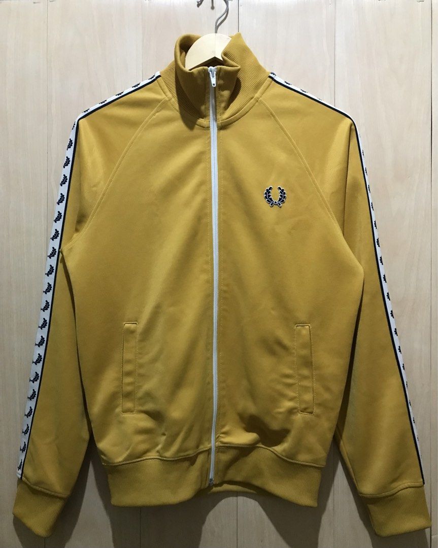 Fred Perry Laurel Taped Track Jacket AUTHENTIC (Category: Coats, Jackets and Outerwear) located in Davao. Submitted by tripgapprl (Listing ID 1469106182, Image 1). Description: Preloved not thrifted Fred Perry track jacket authentic, bought on Japan early 2010. Color: Mustard Dimes: 19.5 width - 26 length Best fit: Mens(Small) Womens(Medium) Size on tag: Xs Condition: 9.6/10 Color rate: 9.5/10 YKK zipper Need wash hem parts Issue: minor white sta