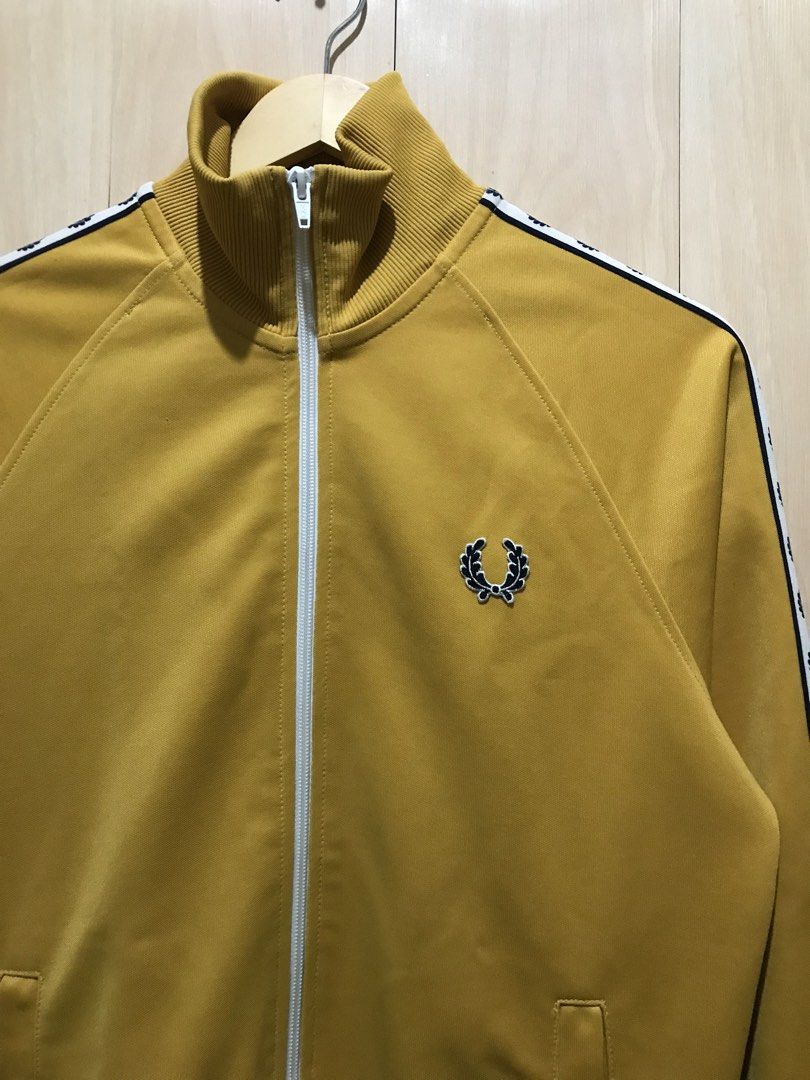 Fred Perry Laurel Taped Track Jacket AUTHENTIC (Category: Coats, Jackets and Outerwear) located in Davao. Submitted by tripgapprl (Listing ID 1469106182, Image 2). Description: Preloved not thrifted Fred Perry track jacket authentic, bought on Japan early 2010. Color: Mustard Dimes: 19.5 width - 26 length Best fit: Mens(Small) Womens(Medium) Size on tag: Xs Condition: 9.6/10 Color rate: 9.5/10 YKK zipper Need wash hem parts Issue: minor white sta