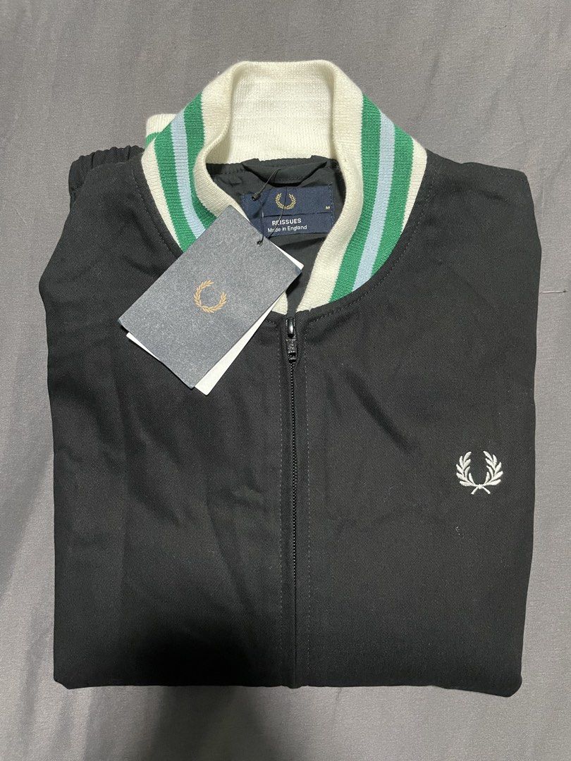 Fred Perry Reissues Bomber Jacket (Category: Coats, Jackets and Outerwear) located in Calapan. Submitted by lucasthrifts (Listing ID 1468945110, Image 2). Description: - Brand: Fred Perry Reissues - Style: Bomber Jacket in Black - Condition: Brand new with tags (BNWT) - Size: Medium (Chest: 21", Length: 27") - Details: White, green, and blue striped ribbed collar and cuffs, full zip closure, dual front slash pockets - Branding: Embroidered laurel