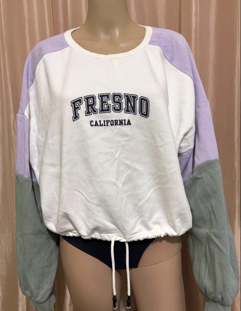 Fresno California Colorblock Pullover Sweatshirt (Category: Coats, Jackets and Outerwear) located in Cainta. Submitted by tokadore (Listing ID 1468955742, Image 1). Description: - Colorblock design in white, light purple, and muted green - Classic crewneck with raglan sleeves - Adjustable drawstring hem for a customizable fit - Dark navy blue graphic text printed across the chest - Long sleeves with comfortable ribbed cuffs - Relaxed, casual ever