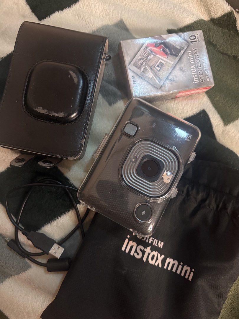 Fujifilm Instax Mini LiPlay Hybrid Instant Camera Bundle (Category: Cameras) located in Valenzuela. Submitted by baby00000 (Listing ID 1469069913, Image 1). Description: - Item: Fujifilm Instax Mini LiPlay Hybrid Instant Camera Set - Condition: Clean and 100% fully functioning - Inclusions: Clear protective case, black leatherette carrying case, branded drawstring pouch, and USB charging cable - Bonus: 1 unopened box of Stone Gray film sheets (10