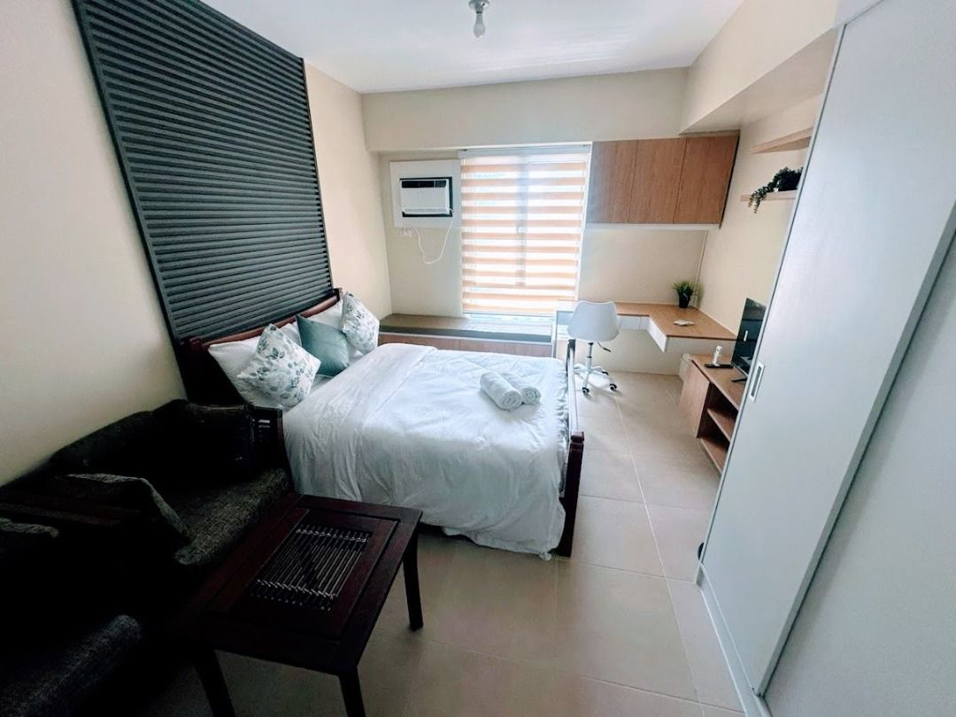 Fully Furnished Studio Unit for Rent (Category: Apartments & Condos) located in Caloocan City. Submitted by itsalonica (Listing ID 1468972762, Image 2). Description: - Compact studio setup with a comfortable double bed and built-in wardrobe - Functional kitchen area with a fridge, sink, and overhead cabinets - Enclosed bathroom featuring a hot and cold shower - Dedicated study desk by the window with a rolling chair - Small dining table for meals
