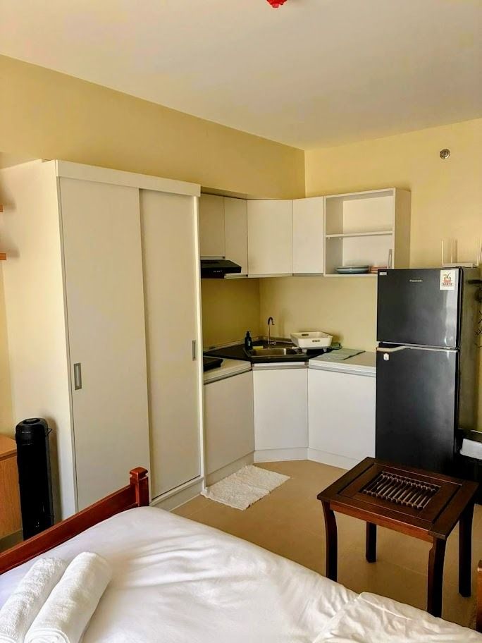 Fully Furnished Studio Unit for Rent (Category: Apartments & Condos) located in Caloocan City. Submitted by itsalonica (Listing ID 1468972762, Image 3). Description: - Compact studio setup with a comfortable double bed and built-in wardrobe - Functional kitchen area with a fridge, sink, and overhead cabinets - Enclosed bathroom featuring a hot and cold shower - Dedicated study desk by the window with a rolling chair - Small dining table for meals