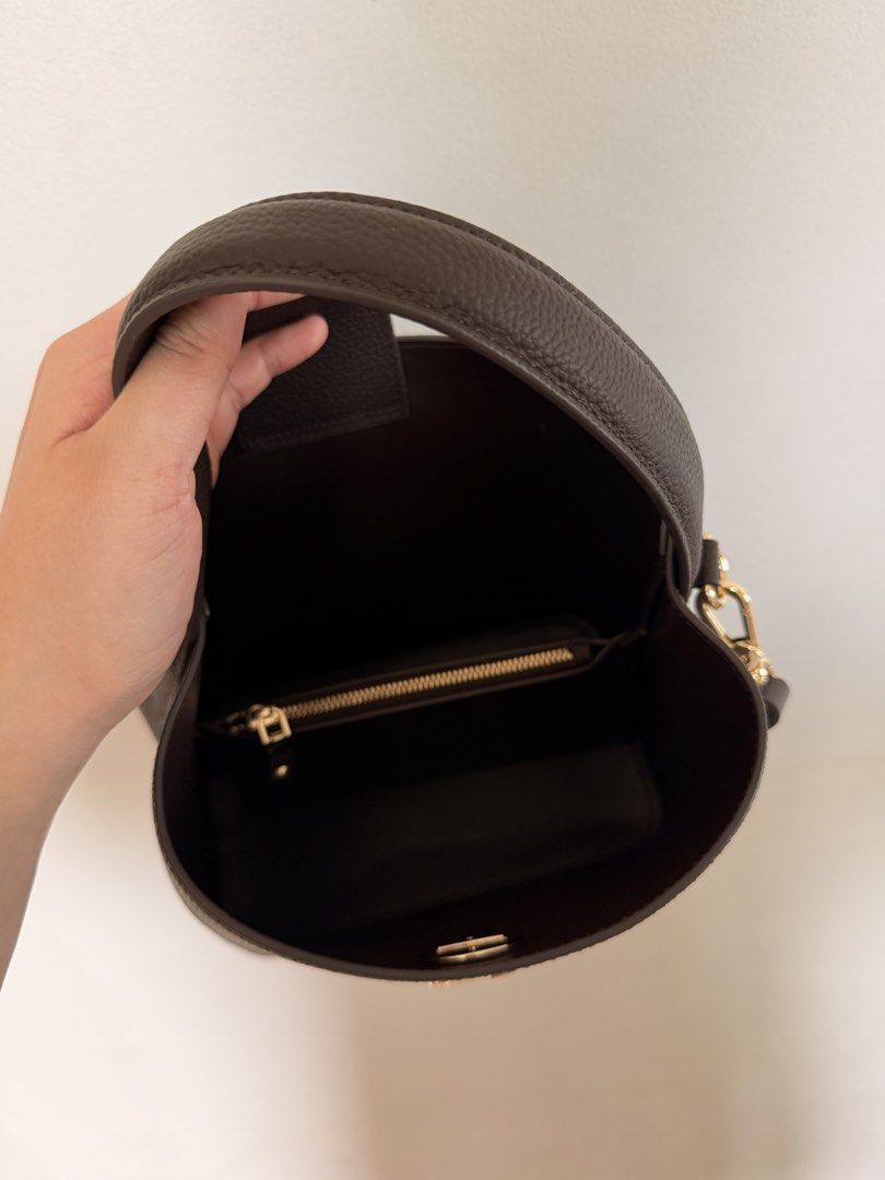 Genuine Leather Bucket Bag (Category: Shoulder Bags) located in Marikina City. Submitted by melsellstuff (Listing ID 1468947377, Image 3). Description: - Material: Dark brown textured leather with gold-tone hardware - Closure: Secure front flap with turn-lock closure - Straps: Includes a matching top handle and a detachable, adjustable shoulder strap - Interior: Dark lining with a zipped pocket; deep space for daily essentials - Condition: New, n