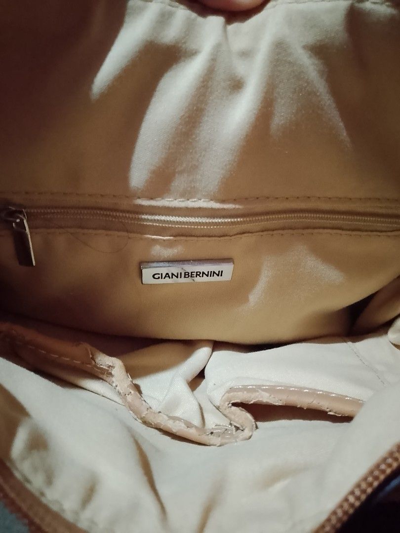 Giani Bernini Floral Shoulder Bag (Category: Shoulder Bags) located in Batangas. Submitted by sheenx.09 (Listing ID 1469022234, Image 3). Description: - Brand: Giani Bernini - Design: Dark brown monogram print with pink rose pattern and tan trim 🫶 - Exterior: Front zipper pocket for easy access ♥️ - Interior: Beige fabric lining with a zipper compartment and metal logo plaque - Condition: Shows visible peeling and wear along the trim and strap e