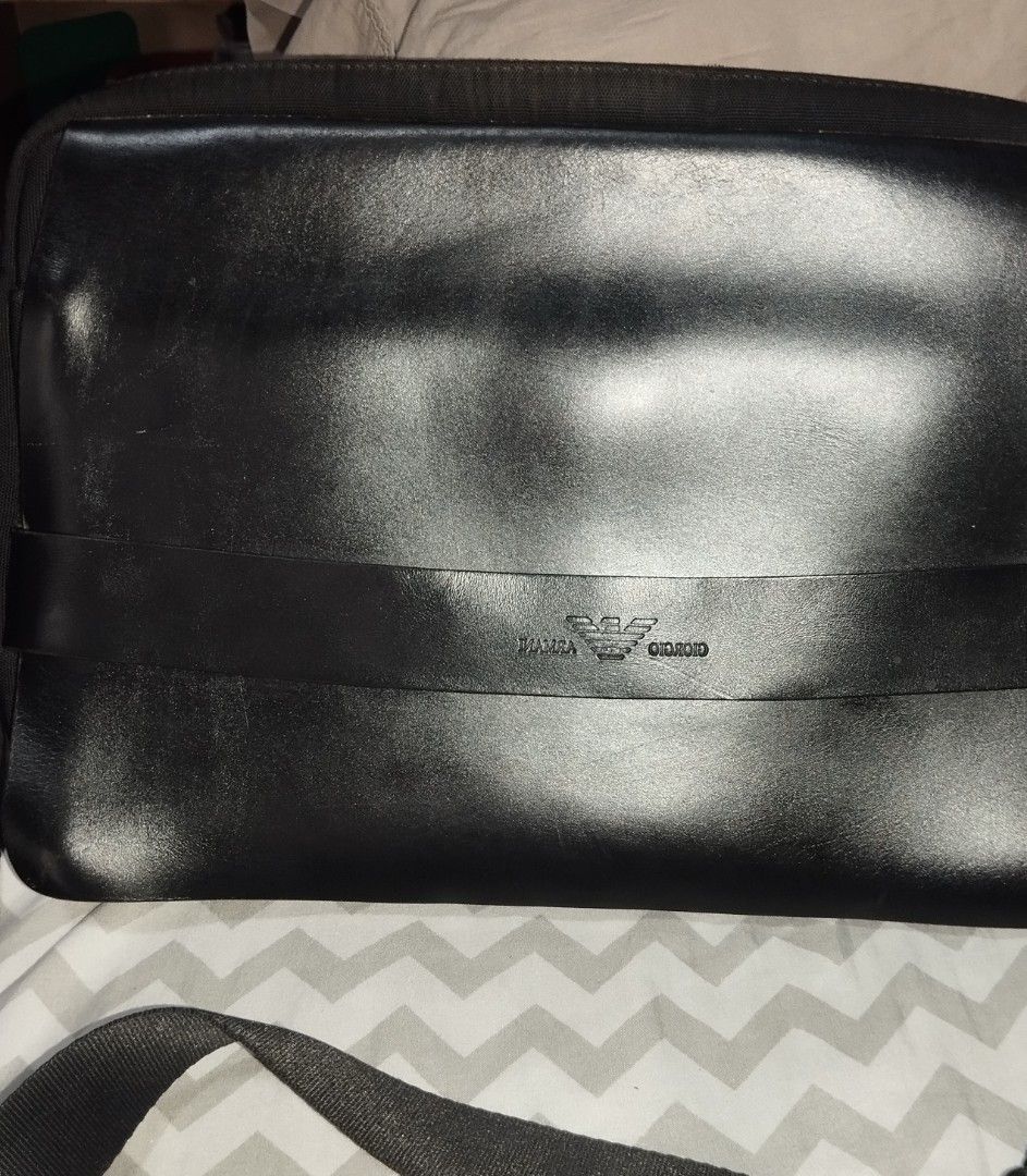 Giorgio Armani Black Leather Messenger Bag (Category: Sling Bags) located in Manila. Submitted by lene48 (Listing ID 1468932093, Image 2). Description: - Brand: Giorgio Armani - Material: Durable fabric with leather accents - Color: Classic black - Design: Embossed logo on front strap and interior lining - Strap: Adjustable shoulder strap with sturdy metal hardware - Storage: Interior zipper pocket for small essentials - Condition: Clean interior