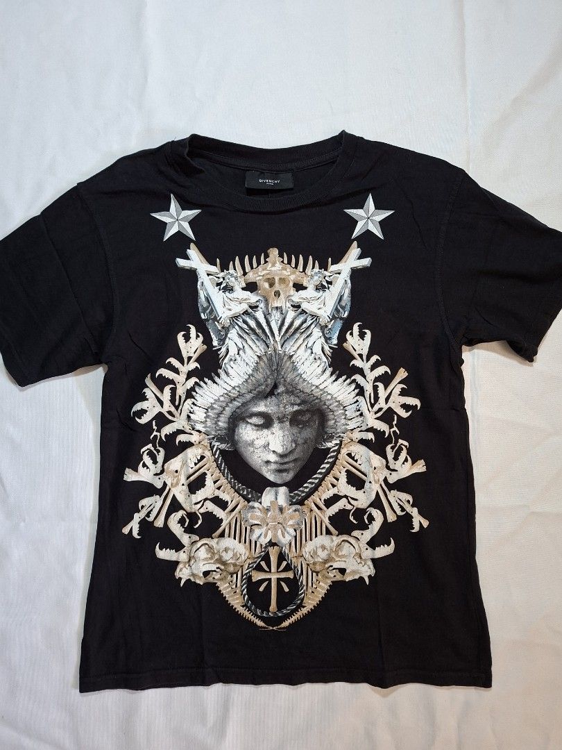 Givenchy Paris Black Graphic Tee (Category: Shirts) located in Baguio. Submitted by restyrille77846 (Listing ID 1469095198, Image 1). Description: - 100% Authentic Givenchy Paris black t-shirt - Striking front graphic print featuring winged face, skulls, stars, and cross details - Classic crew neck, short sleeves, and standard fit - Premium cotton jersey fabric for ultimate comfort - Interior brand tag intact - Care: Machine wash inside out - Con