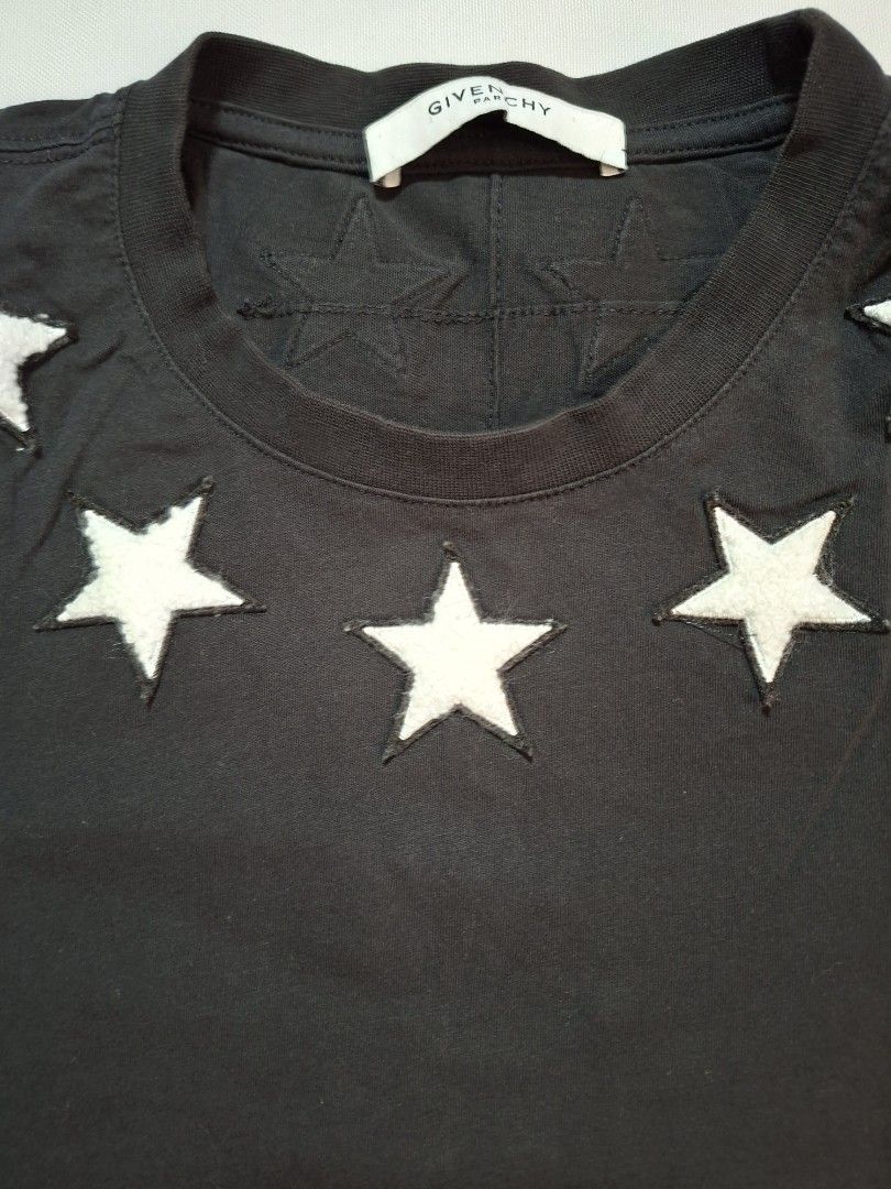 Givenchy Paris Star Patch Short Sleeve T-Shirt Black (Category: Shirts) located in Baguio. Submitted by restyrille77846 (Listing ID 1469069938, Image 2). Description: - Brand: Givenchy Paris - Color: Black with white accents - Material: Premium quality cotton - Design: White star patches around the neckline - Details: Number 1 and 4 prints on the short sleeves - Fit: Classic crew neck, ideal for streetwear - Condition: Great designer piece.