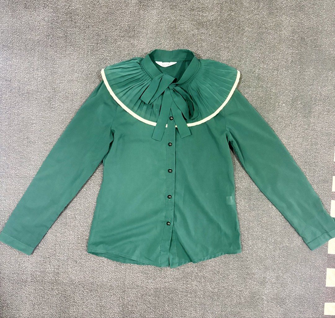Green pleated collar long sleeve button down blouse (Category: Longsleeves) located in Quezon City. Submitted by fast.closetfinds (Listing ID 1469018432, Image 1). Description: - Color: Emerald green - Material: Lightweight, slightly sheer chiffon - Details: Large pleated contrast collar, matching neck tie, dark front buttons - Sleeve: Long sleeve - Condition: Clean, worn a few times.
