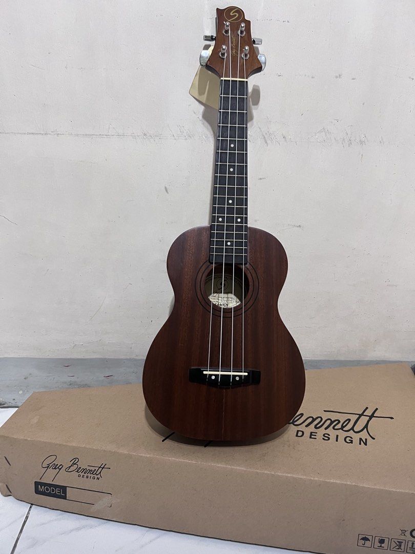 Greg Bennett Design Samick Ukulele (Category: Musical Instruments) located in Quezon City. Submitted by john7434350672 (Listing ID 1469160813, Image 2). Description: - Model: Greg Bennett Design Samick UK-507NS concert ukulele - Condition: Brand new with factory tags and QC sticker still attached - Appearance: Rich brown wood finish with a clean fretboard - Hardware: Equipped with smooth nylon strings - Inclusions: Comes complete with the origina