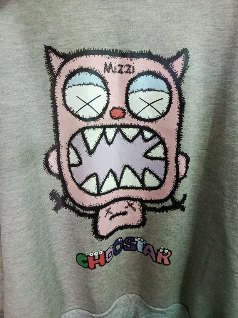 Grey Crewneck Sweatshirt with Graphic Print (Category: Coats, Jackets and Outerwear) located in Cabatuan. Submitted by penthegreat (Listing ID 1469111125, Image 2). Description: No tags/washtags - Colour: Grey - Fit: Relaxed fit with soft cotton-blend fabric - Design: Large pink monster graphic on chest with 'Mizzi' and colourful 'CHOOSSTAR' lettering - Details: Ribbed collar, cuffs, and hem for added comfort - Condition: Brand new and ready to w