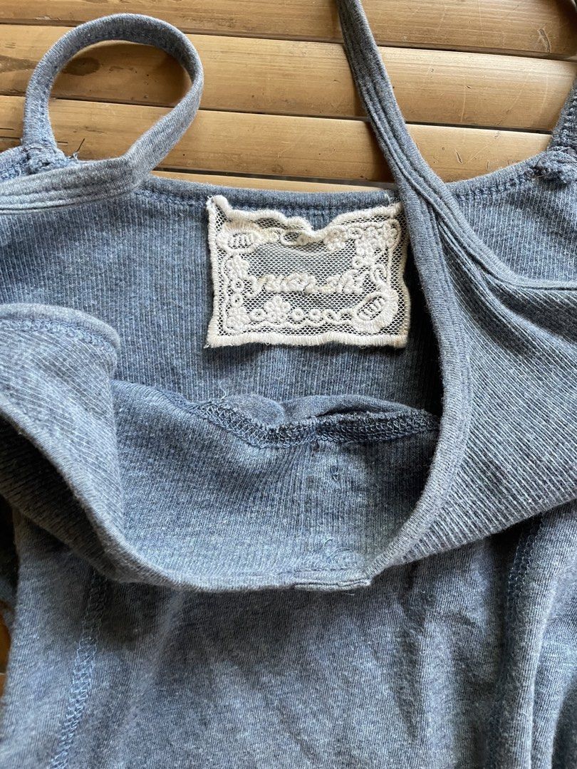 Grey Ribbed Tank Top with Buttons (Category: Sleeveless) located in Manila. Submitted by declutterwithme07 (Listing ID 1469013683, Image 3). Description: - Color: Grey - Material: Ribbed fabric - Design: Scoop neckline with thin spaghetti straps - Details: Two small buttons at the front, panel seams on front and back - Fit: Fitted silhouette - Special Feature: Unique vintage-style embroidered brand label inside the back collar.