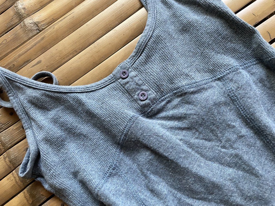 Grey Ribbed Tank Top with Buttons (Category: Sleeveless) located in Manila. Submitted by declutterwithme07 (Listing ID 1469013683, Image 2). Description: - Color: Grey - Material: Ribbed fabric - Design: Scoop neckline with thin spaghetti straps - Details: Two small buttons at the front, panel seams on front and back - Fit: Fitted silhouette - Special Feature: Unique vintage-style embroidered brand label inside the back collar.