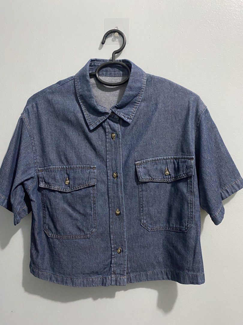 GU Blue Denim Short Sleeve Button Up Shirt (Category: Shirts) located in Mandaluyong City. Submitted by _adjh (Listing ID 1469143576, Image 1). Description: - Brand: GU - Item: Denim short-sleeve shirt - Color: Blue - Material: 100% cotton - Fit: Boxy cropped fit - Details: Button-front closure, classic collar, two chest pockets with button flaps, and upper back pleats.