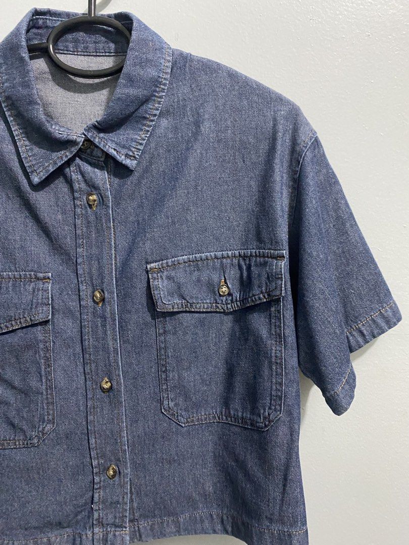 GU Blue Denim Short Sleeve Button Up Shirt (Category: Shirts) located in Mandaluyong City. Submitted by _adjh (Listing ID 1469143576, Image 2). Description: - Brand: GU - Item: Denim short-sleeve shirt - Color: Blue - Material: 100% cotton - Fit: Boxy cropped fit - Details: Button-front closure, classic collar, two chest pockets with button flaps, and upper back pleats.
