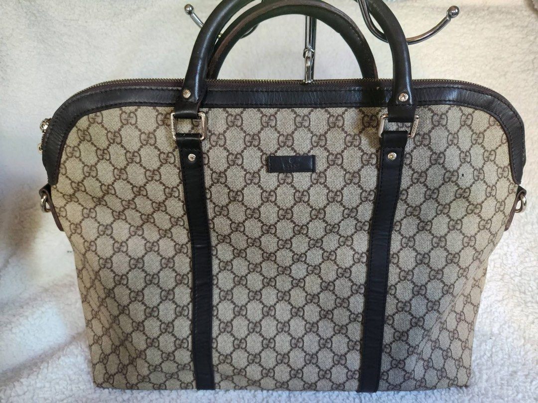 Gucci GG Monogram Canvas Tote Handbag (Category: Luxury Bags & Wallets) located in Bauang. Submitted by Fuzakenn (Listing ID 1469015990, Image 1). Description: - Brand: Gucci - Style: Monogram canvas tote bag with dark brown leather trim and handles - Closure: Top zip closure with engraved zipper pull - Interior: Fabric lining with slip pockets and a zippered pocket - Condition Notes: Hardware shows minor wear; interior lining has visible discolo