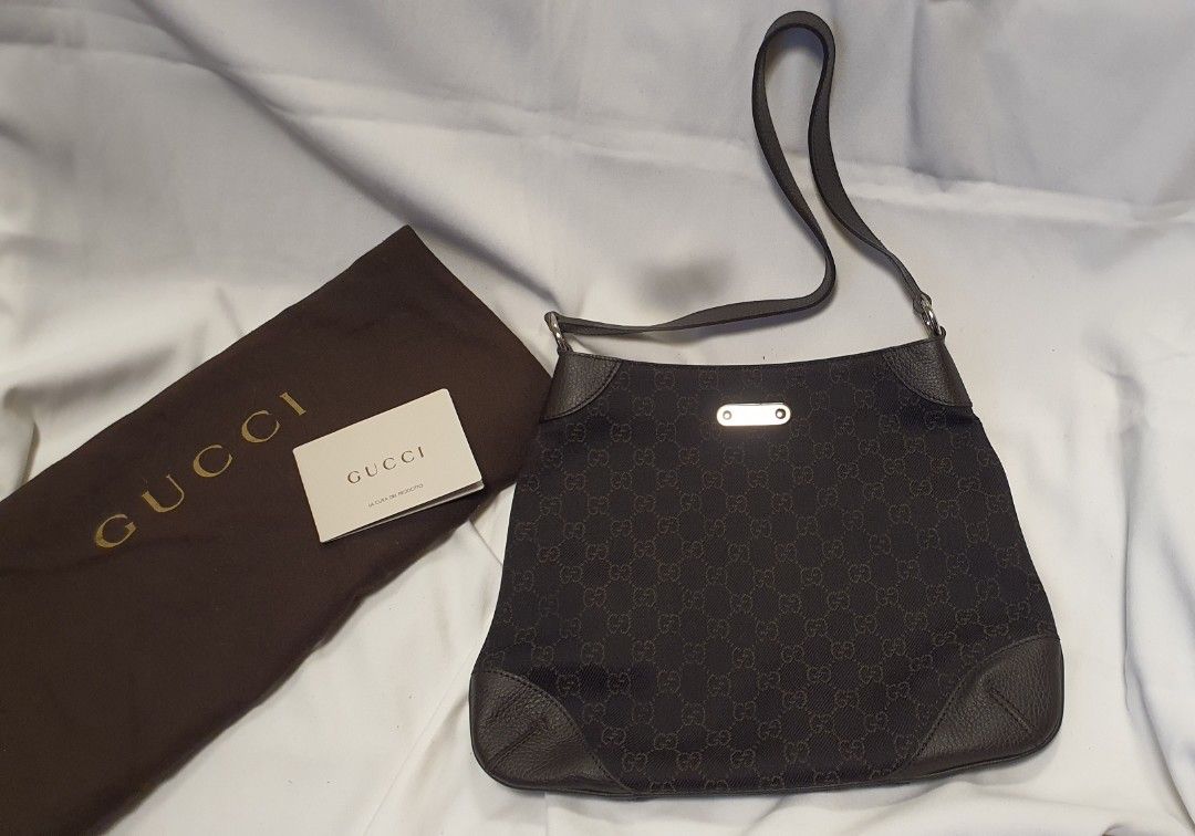 Gucci Monogram Canvas Shoulder Bag (Category: Luxury Bags & Wallets) located in Pasig City. Submitted by angel025 (Listing ID 1468966795, Image 1). Description: - Authentic Brown Gucci Monogram canvas shoulder bag - Dark leather trim with stylish silver-tone hardware - - Front metal plaque featuring engraved Gucci branding - Comfortable single slim shoulder strap - Pristine and clean condition inside and out - Includes original brown dust bag and