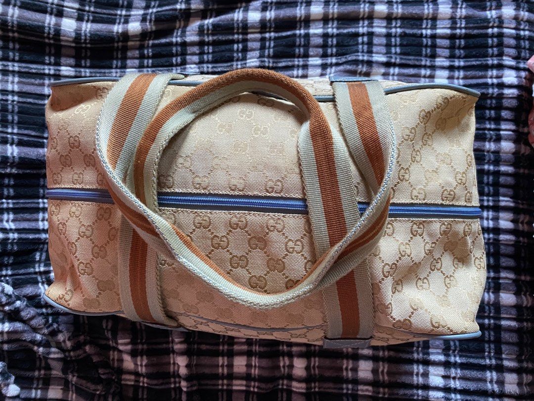 Gucci GG Fabric Duffle Bag (Category: Luxury Bags & Wallets) located in San Fernando. Submitted by keysjeyshop (Listing ID 1469109897, Image 3). Description: Vintage Gucci GG Fabric Duffle Bag -Size: Width - 20 Height - 11.5Depth - 7 -issue: faded print parts at the back of the back, the zipper handle broken and have some minor dents. - condition is still okay, using it for the last 7years. pm for more infos .