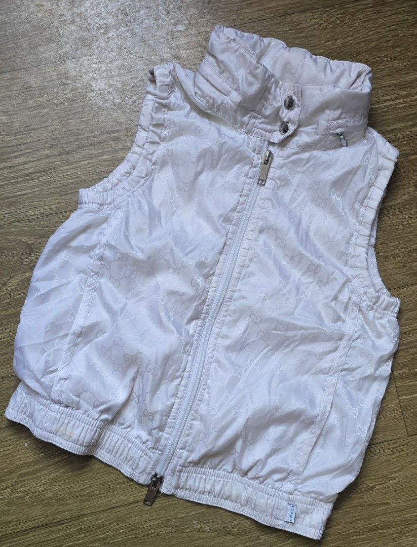 Gucci White Monogram Hooded Zip Vest (Category: Luxury Apparel) located in Quezon. Submitted by archivesss_666 (Listing ID 1469011136, Image 1). Description: for 6 yrs old - Authentic Gucci children's zip vest in white - Features all-over interlocking G monogram pattern - Stand collar with hidden zip-off hood - Ribbed hem and arm openings for a comfortable fit - Zip front closure with branded Gucci hardware - Inner Gucci tag and care label attach