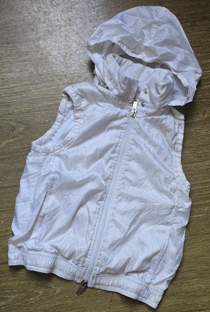 Gucci White Monogram Hooded Zip Vest (Category: Luxury Apparel) located in Quezon. Submitted by archivesss_666 (Listing ID 1469011136, Image 2). Description: for 6 yrs old - Authentic Gucci children's zip vest in white - Features all-over interlocking G monogram pattern - Stand collar with hidden zip-off hood - Ribbed hem and arm openings for a comfortable fit - Zip front closure with branded Gucci hardware - Inner Gucci tag and care label attach