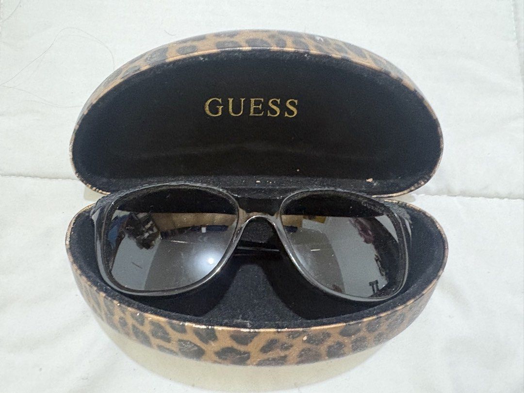 GUESS GU7401 Polarized Sunglasses with Case (Category: Sunglasses & Eyewear) located in Manila. Submitted by nykji96 (Listing ID 1468952342, Image 2). Description: - Brand/Model: Guess Polarized Sunglasses (GU7401 01D, 56-16-135 3P) - Color: Classic Black frame with polarized lenses - Condition: Lenses and frames are spotless and clean - Inclusion: Original hard glasses case featuring a stylish metallic gold leopard print pattern - Case Condition