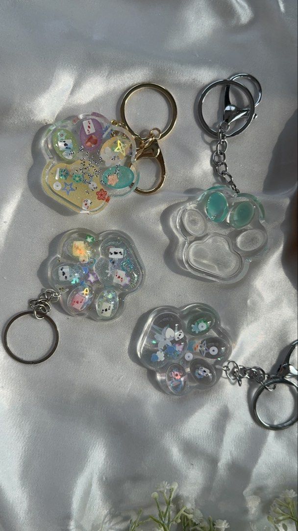 Handmade Resin Cat Paw Keychain (Category: Accessory Holder, Box & Organizers) located in Pasay City. Submitted by saroosss (Listing ID 1469089184, Image 2). Description: - Handmade cat paw resin keychain - Filled with cute charms, glitter, and sequins - One-of-a-kind piece - Sturdy metal keyring and chain - Perfect accessory for keys, bags, or pouches.