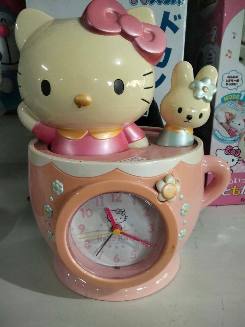 Hello Kitty Teacup Alarm Clock with Bunny (Category: Clocks) located in Santa Cruz. Submitted by madonnaching (Listing ID 1469017397, Image 1). Description: - Adorable Kitty themed desk clock shaped like a charming pink teacup - Features Kitty with her signature pink bow and a cute little bunny figurine on top - Built-in analog clock face on the front, beautifully decorated with flowers - Perfect fun accessory for your desk, study table, or bedsi