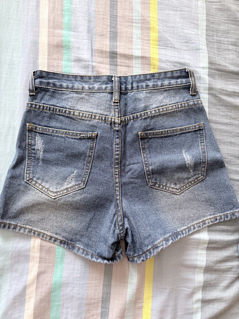 high-waisted denim shorts (Category: Shorts) located in Paranaque City. Submitted by roanclauds (Listing ID 1468950918, Image 2). Description: - High waist denim shorts in medium blue wash - Size: XS (24 in) - 100% cotton, designed by Korea - Distressed details on front and back pockets - Button closure and zip fly - Standard five-pocket styling with clean stitching and light fading.