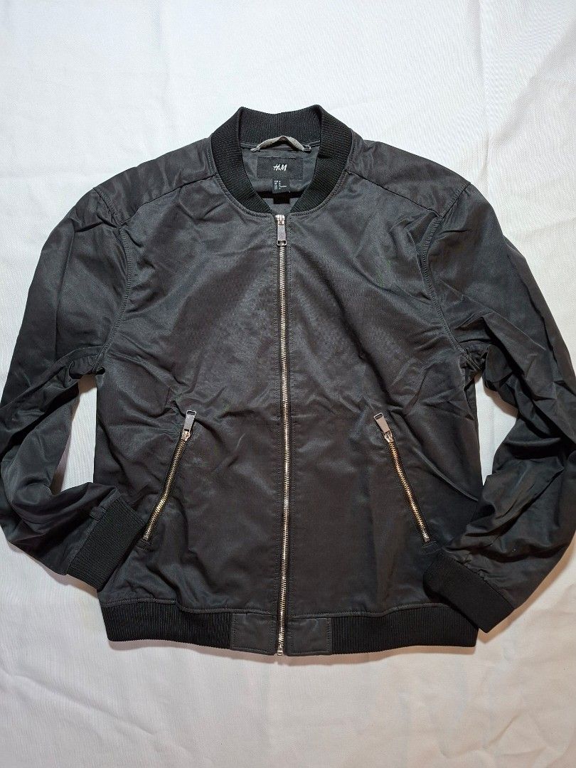 H&M Black Bomber Jacket Size M (Category: Coats, Jackets and Outerwear) located in Baguio. Submitted by restyrille77846 (Listing ID 1469149736, Image 1). Description: - Brand: H&M - Item: Black Bomber Jacket - Size: Medium (175/100A) - Material: 47% polyester, 44% polyamide, 9% cotton - Features: Full zip front, matching side zipper pockets, ribbed collar, cuffs, and hem - Measurement: ~24 inches across the bottom band - Condition: Solid construc