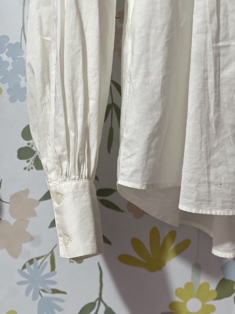 H&M White V-Neck Blouse Size M oversized (Category: Blouses) located in Pasig City. Submitted by morilove (Listing ID 1469054566, Image 3). Description: - Brand: H&M - Size: M - Color: White - Neckline: Split V-neck with mandarin collar - Sleeves: Long sleeves with buttoned cuffs and gathered detailing - Hem: Curved hem - Material: Lightweight fabric - Condition: Clean and well-maintained - Style: Classic casual staple, perfect for work or weeken