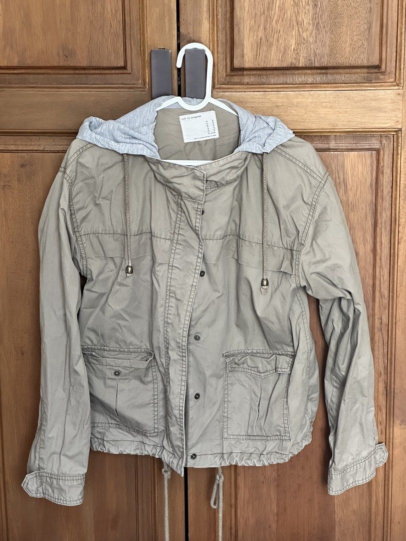 Hooded Utility Jacket Size S (Category: Coats, Jackets and Outerwear) located in Taguig. Submitted by melsofficewear (Listing ID 1468976659, Image 2). Description: - Color: Neutral beige with contrasting grey hooded insert - Closure: Full zip and secure snap button front - Pockets: Two functional front patch pockets with button flaps - Fit & Style: Adjustable drawstrings at the hem and hood, long sleeves with button cuffs - Condition: Great layer