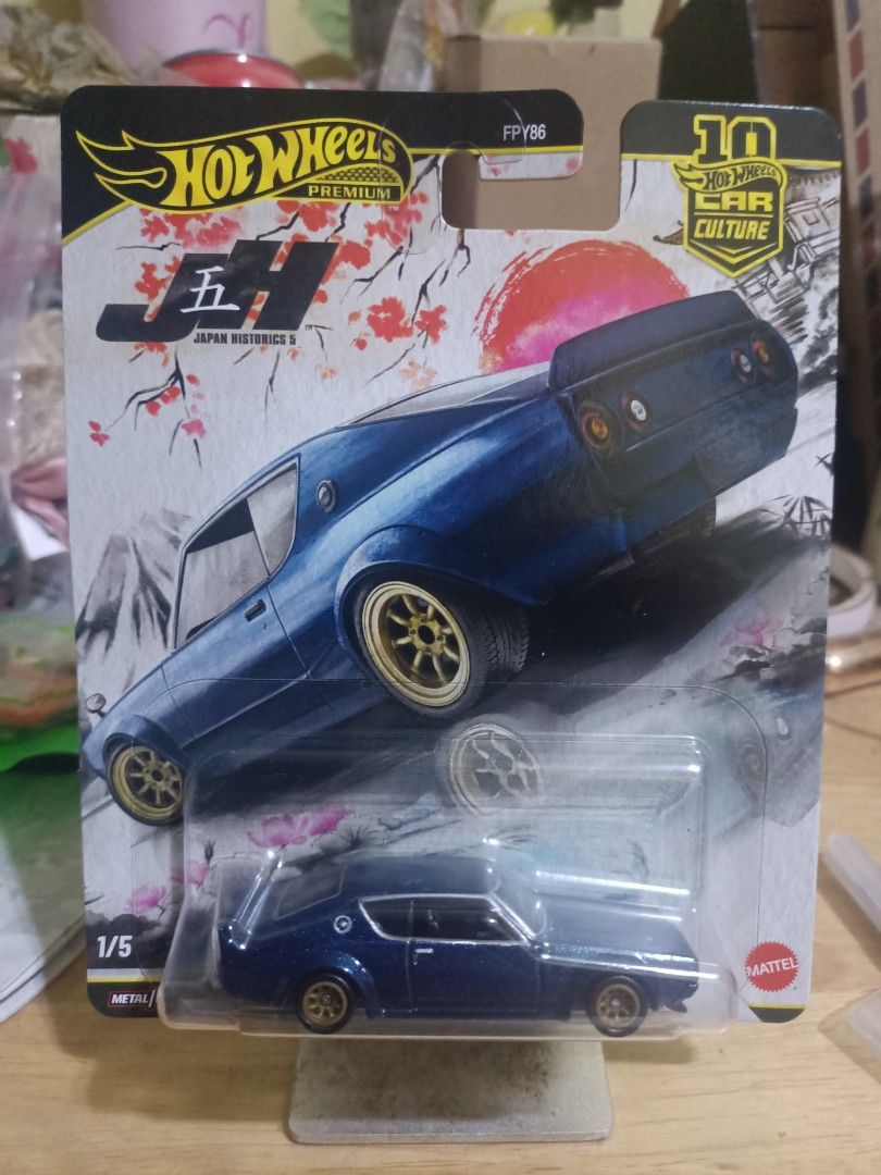 Hot Wheels (Category: Vehicle & Diecast Models) located in Dasmarinas. Submitted by jimzvcra (Listing ID 1469005164, Image 1). Description: - Series: Hot Wheels Premium Car Culture - Japan Historics 5 - Vehicle: Dark blue diecast with gold wheels - Number: 1 out of 5 in the set - Packaging: Unopened blister pack with cherry blossom and sun artwork - Condition: Brand new, original packaging.