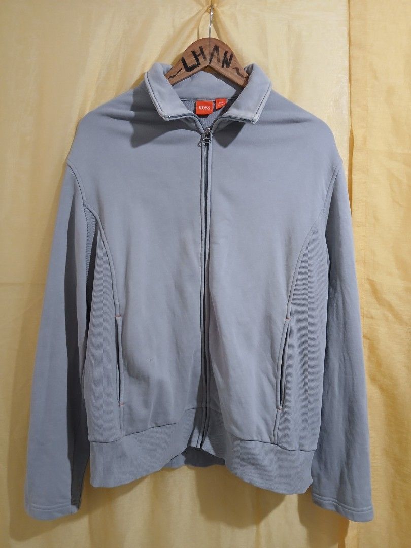 HUGO BOSS Full Zip Jacket Light Blue Size L (Category: Coats, Jackets and Outerwear) located in Taguig. Submitted by thriftnilhan (Listing ID 1468942741, Image 1). Description: - Brand: HUGO BOSS - Size: L - Color: Light Blue - Origin: Made in Thailand - Design: Full zip with ribbed side panels, collar, cuffs, and hem - Pockets: Front zip pockets featuring subtle contrast stitching - Branding: BOSS logo printed on the back near the collar - Care: