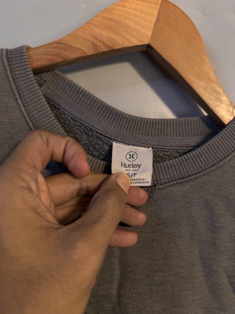 Hurley Grey Sweatshirt Size S (Category: Coats, Jackets and Outerwear) located in Alaminos. Submitted by outfitcheck.ph (Listing ID 1469102733, Image 2). Description: - Brand: Hurley - Color: Grey - Size: Small - Material: Comfortable cotton blend, great for layering - Details: Embroidered brand logo across the chest, ribbed V-stitch detail under the collar, ribbed cuffs and hem - Condition: Excellent pre-loved condition.