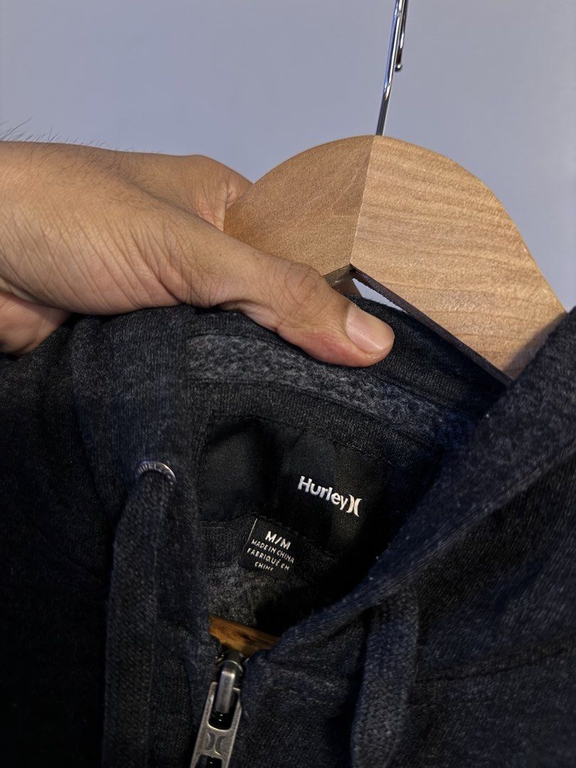 Hurley Zip-Up Hoodie Dark Grey Blue Script Logo Size M (Category: Coats, Jackets and Outerwear) located in Alaminos. Submitted by outfitcheck.ph (Listing ID 1469102003, Image 3). Description: - Brand: Hurley - Style: Dark grey marled zip-up hoodie - Size: Medium - Details: Bright blue embroidered script logo on chest, drawstring hood, front kangaroo pocket, ribbed cuffs and hem - Material: Soft and mid-weight - Condition: Clean, zippers work smoo