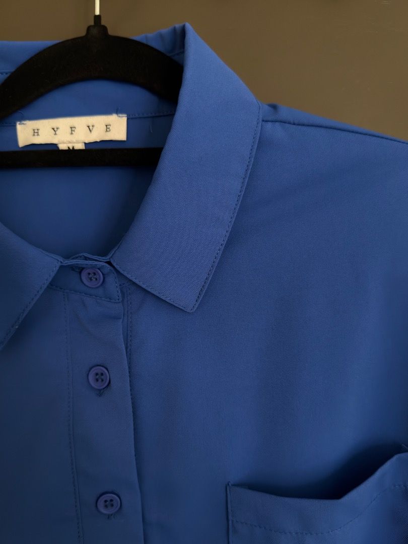 HYFVE Royal Blue Button Up Crop Blouse (Category: Blouses) located in Calamba. Submitted by prongsiepoo (Listing ID 1469079736, Image 3). Description: - Brand: Hyfve - Color: Bright royal blue - Fit: Relaxed fit through the body - Details: Collared neck, short sleeves, and two front chest pockets - Feature: Adjustable drawstring hem for waist cinching - Material: Lightweight fabric.