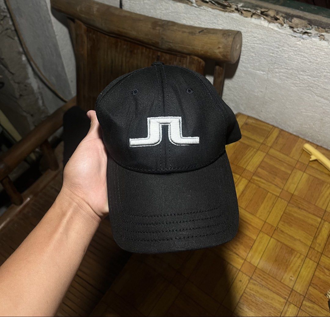j.lindeberg Black Baseball Cap (Category: Caps & Hats) located in Pontevedra. Submitted by thrift01 (Listing ID 1469047472, Image 1). Description: - Brand: J.Lindeberg - Color: Classic Black with White Embroidered Bridge Logo - Details: Brand name embroidered on the back and inner lining - Design: Classic curved brim and structured panels - Condition: Clean interior with size tag (Made in China) - Best for: Golf, sports, or casual everyday wear -