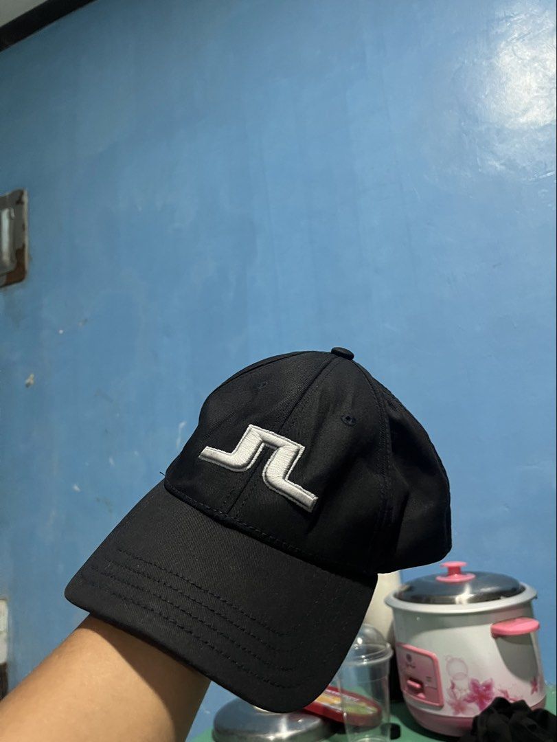 j.lindeberg Black Baseball Cap (Category: Caps & Hats) located in Pontevedra. Submitted by thrift01 (Listing ID 1469047472, Image 2). Description: - Brand: J.Lindeberg - Color: Classic Black with White Embroidered Bridge Logo - Details: Brand name embroidered on the back and inner lining - Design: Classic curved brim and structured panels - Condition: Clean interior with size tag (Made in China) - Best for: Golf, sports, or casual everyday wear -
