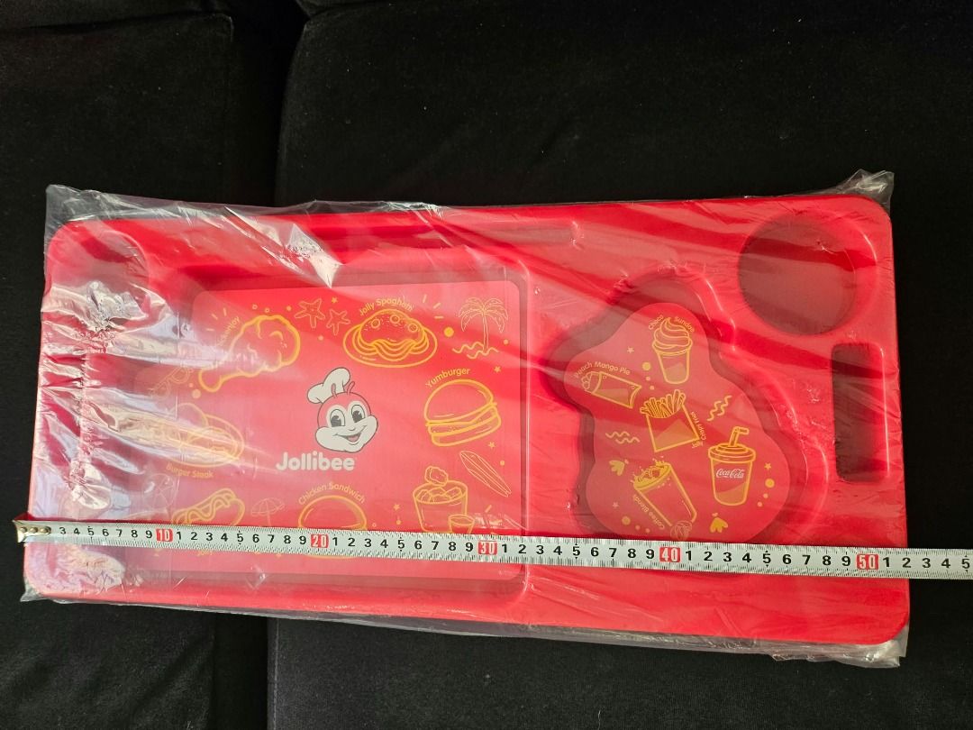Jollibee Red Plastic Travel Tray (Category: Upholstery, Seatcovers and Other Interior Parts and Accessories) located in Valenzuela. Submitted by habejavier (Listing ID 1469026201, Image 3). Description: - Authentic Jollibee red plastic travel tray with classic menu and mascot graphics - Brand new and still sealed in its original protective plastic packaging - Practical rectangular design featuring built-in cup holders and segmented food compartme