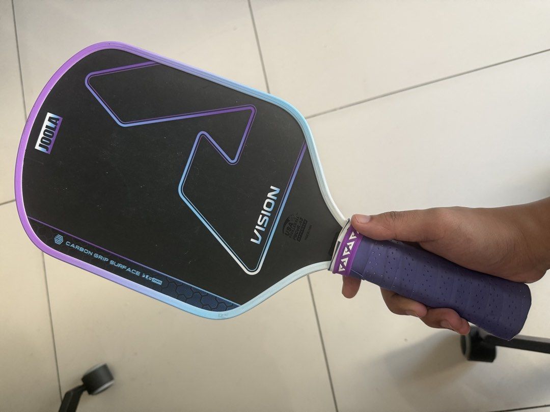 JOOLA Vision Carbon Grip Pickleball Paddle 16mm (Category: Racket and Ball Sports) located in Bulacan. Submitted by jopbooks (Listing ID 1469037302, Image 1). Description: - Brand/Model: JOOLA Vision pickleball paddle - Core/Surface: 16mm carbon grip surface with textured hitting area - Design: Eye-catching purple and blue gradient with JOOLA edge guard branding - Handle: Wrapped in comfortable purple perforated grip tape - Condition: Standard sh