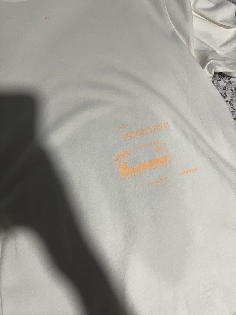 Jordan 23 Engineered White T-Shirt (Category: Tshirts & Polo Shirts ) located in Maasin. Submitted by niconii090 (Listing ID 1468986162, Image 2). Description: - Brand/Model: Jordan 23 Engineered t-shirt - Color: White with orange graphic print and back text details - 📏 21 x 26 (inches) - Condition: Great streetwear staple, clean neckline, material tags intact inside collar - Styling: Easy to pair with shorts or denim.