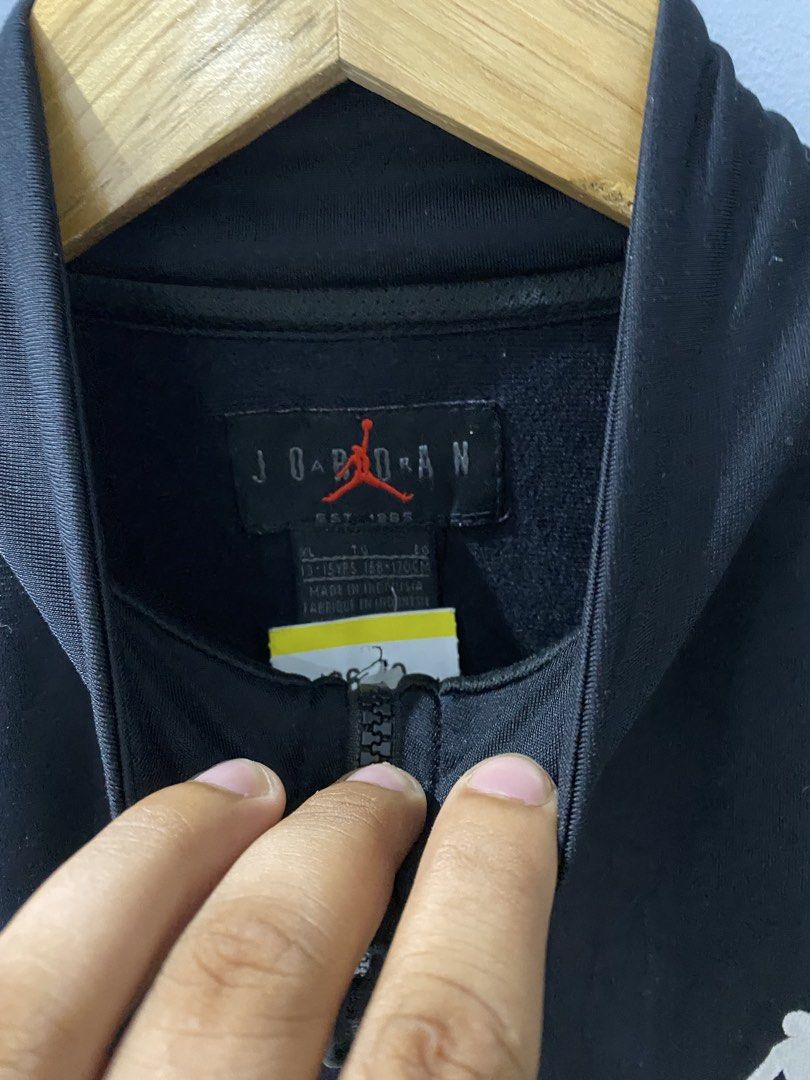 Jordan Black Track Jacket Youth XL (Category: Coats, Jackets and Outerwear) located in Bangued. Submitted by koroysthrifts (Listing ID 1469073082, Image 3). Description: - Brand: Jordan 20x25 - Color: Black with white side panels and branded tape - Details: Embroidered Jumpman logo with blue and red Air text, full zip, high collar, ribbed cuffs and hem - Size: Youth XL (fits ages 13-15 years / height 158-170 cm) - Material: Polyester (Made in Ind