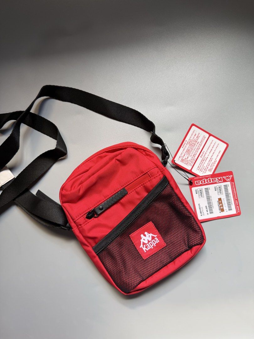 Kappa Red Crossbody Bag (Category: Sling Bags) located in Manila. Submitted by mut_blvr (Listing ID 1468953218, Image 2). Description: - Brand: Kappa - Color: Red with black straps and logo patch - Condition: Brand new with original retail tags attached - Material: 100% polyester interior lining - Features: Front mesh pocket and adjustable shoulder strap - Size: Practical everyday size for essentials - Original Authentic - Shipping via J&T, pay b