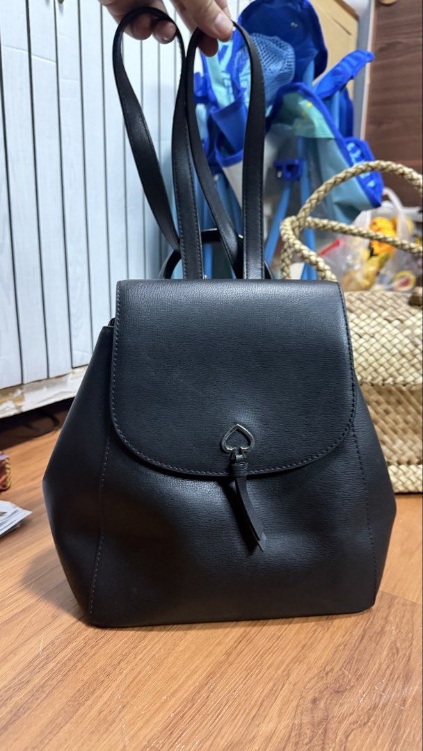 Kate Spade New York Black Leather Backpack (Category: Backpacks) located in Valenzuela. Submitted by ruichi080607 (Listing ID 1468982474, Image 1). Description: Black leather backpack from Kate Spade New York. Flap closure with silver-tone spade lock hardware. Top handle and adjustable shoulder straps. Exterior slip pocket on the back. Cream fabric lining with spade jacquard pattern inside, zippered pocket, and inner tag. Structured shape, classi