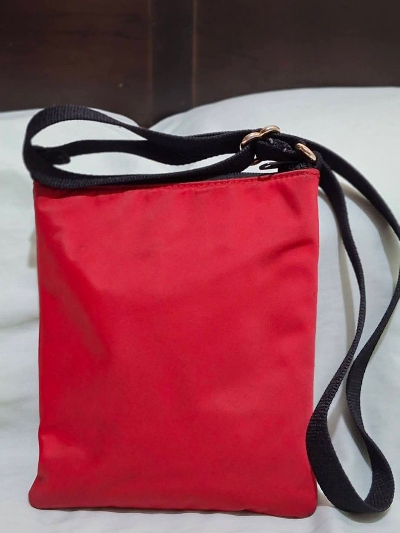 Kate Spade Red Nylon Crossbody Bag (Category: Cross-body Bags) located in Manila. Submitted by closetprincess (Listing ID 1468959378, Image 2). Description: - Brand: Kate Spade - Color: Vibrant red nylon with black straps and hardware - Closure: Secure zip-top closure - Pockets: Convenient front exterior zipped pocket for quick-access items - Strap: Adjustable black webbing strap for shoulder or crossbody wear - Design: Compact, classic rectangul