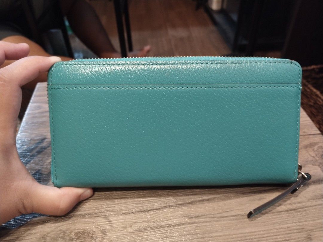 Kate Spade Teal Blue Zip Around Wallet (Category: Wallets & Card holders) located in Calamba. Submitted by callcay (Listing ID 1469080221, Image 3). Description: - Brand: Kate Spade New York - Color: Vibrant teal blue - Material: Genuine leather with signature printed fabric lining - Hardware: Gold-toned with front metal logo plate - Closure: Zip-around with leather zipper pull - Compartments: Multiple card slots, cash compartments, and internal 