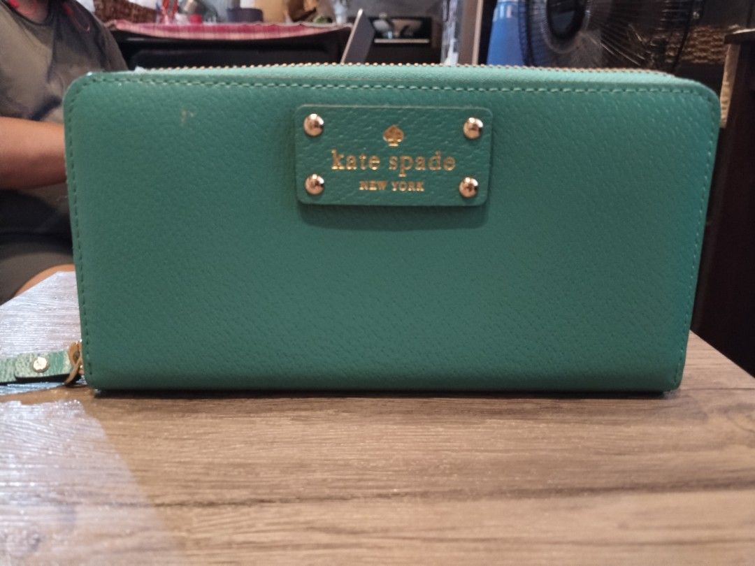 Kate Spade Teal Blue Zip Around Wallet (Category: Wallets & Card holders) located in Calamba. Submitted by callcay (Listing ID 1469080221, Image 1). Description: - Brand: Kate Spade New York - Color: Vibrant teal blue - Material: Genuine leather with signature printed fabric lining - Hardware: Gold-toned with front metal logo plate - Closure: Zip-around with leather zipper pull - Compartments: Multiple card slots, cash compartments, and internal 