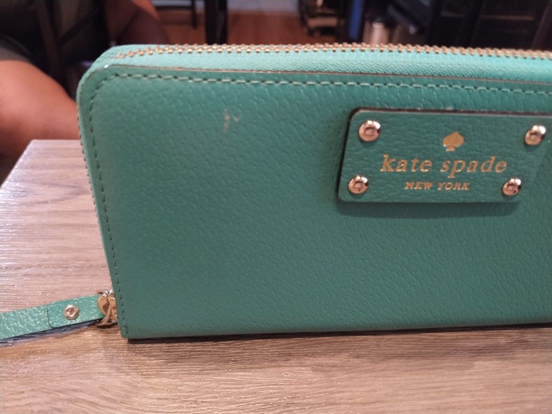 Kate Spade Teal Blue Zip Around Wallet (Category: Wallets & Card holders) located in Calamba. Submitted by callcay (Listing ID 1469080221, Image 2). Description: - Brand: Kate Spade New York - Color: Vibrant teal blue - Material: Genuine leather with signature printed fabric lining - Hardware: Gold-toned with front metal logo plate - Closure: Zip-around with leather zipper pull - Compartments: Multiple card slots, cash compartments, and internal 