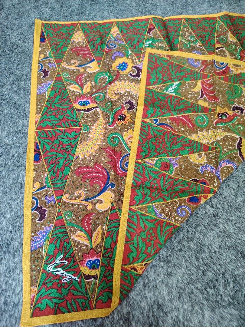 KENZO PANYO 180 each (Category: Handkerchief & Pocket Squares) located in Valenzuela. Submitted by anna.banana10 (Listing ID 1469094403, Image 3). Description: - Brand: Kenzo - Design: Traditional batik style with geometric triangular panels, floral, and paisley motifs - Colors: Green, red, brown, and yellow border - Details: Features signature Kenzo branding on the corner - Condition: Nice vintage accessory - Usage: Easy to fold and slip into a 